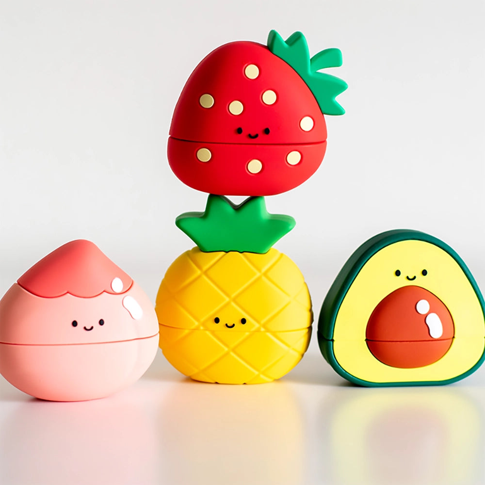 Three Jollie Giggle name stamps (Peachy Pochi, Piney Pineapple and Velvety Avo) lined up side by side on the table with the fourth stamp Strawberry Smile stacked on top of Piney Pineapple in the middle